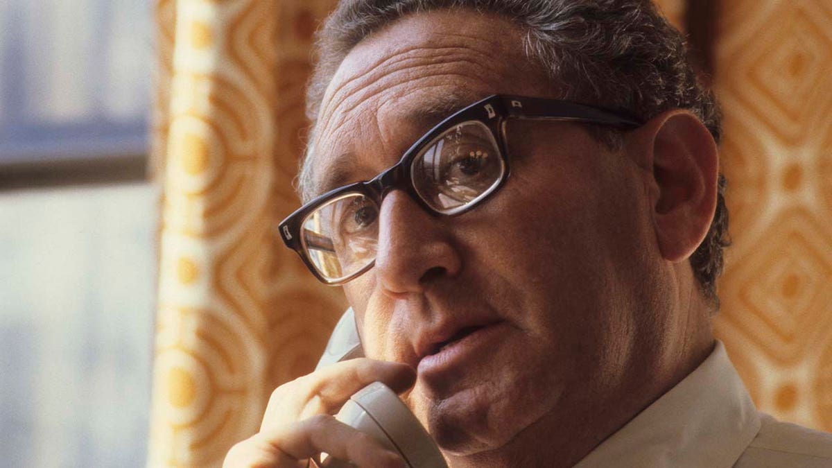 Former Sec. of State Henry Kissinger speaks on a phone