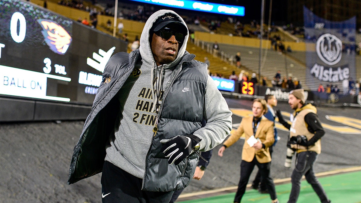 Deion Sanders jogs around the field