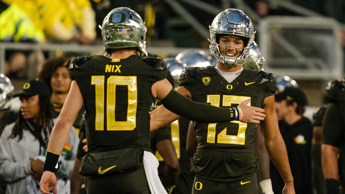 Quarterback Bo Nix high-fives his teammate