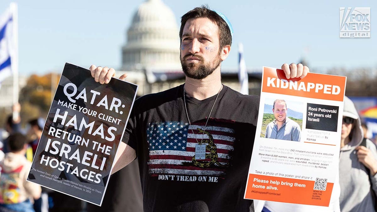 Demonstrators hold signs showing Israeli hostages kidnapped by Hamas at the March for Israel