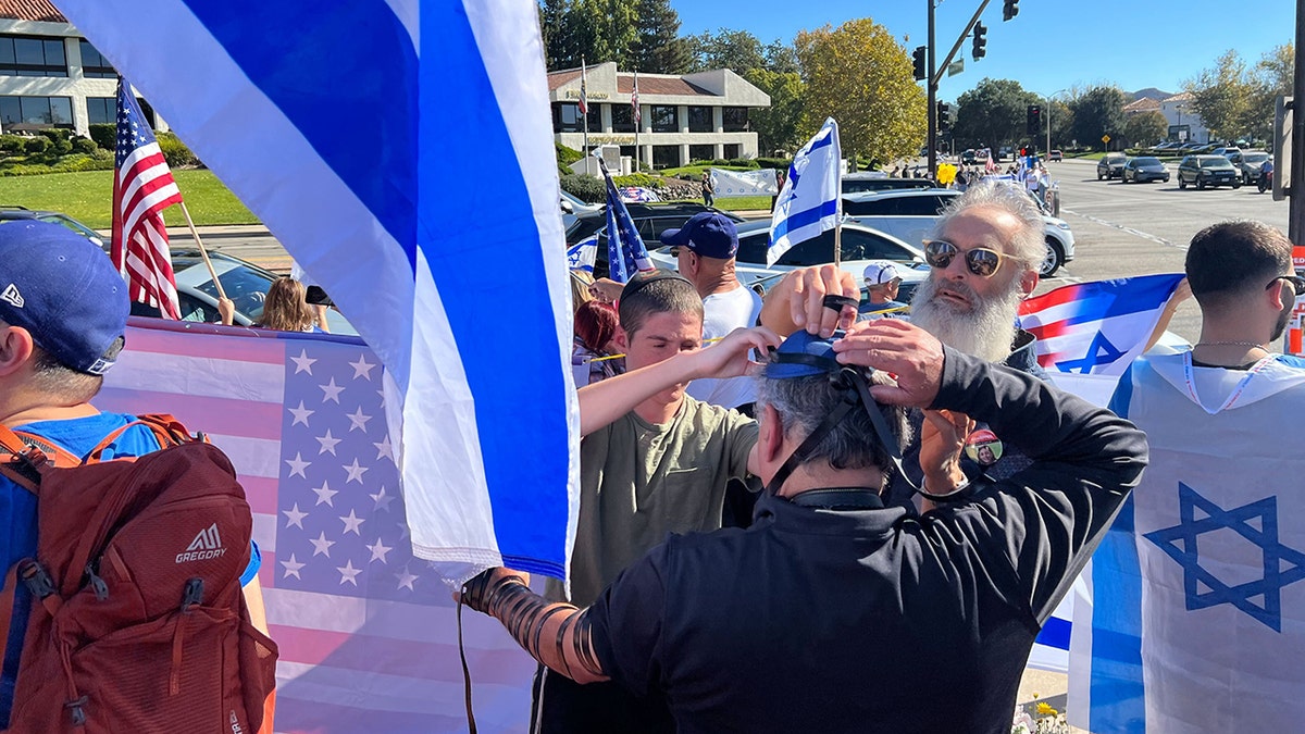 Attendees of Paul Kessler memorial pray with Tefillin