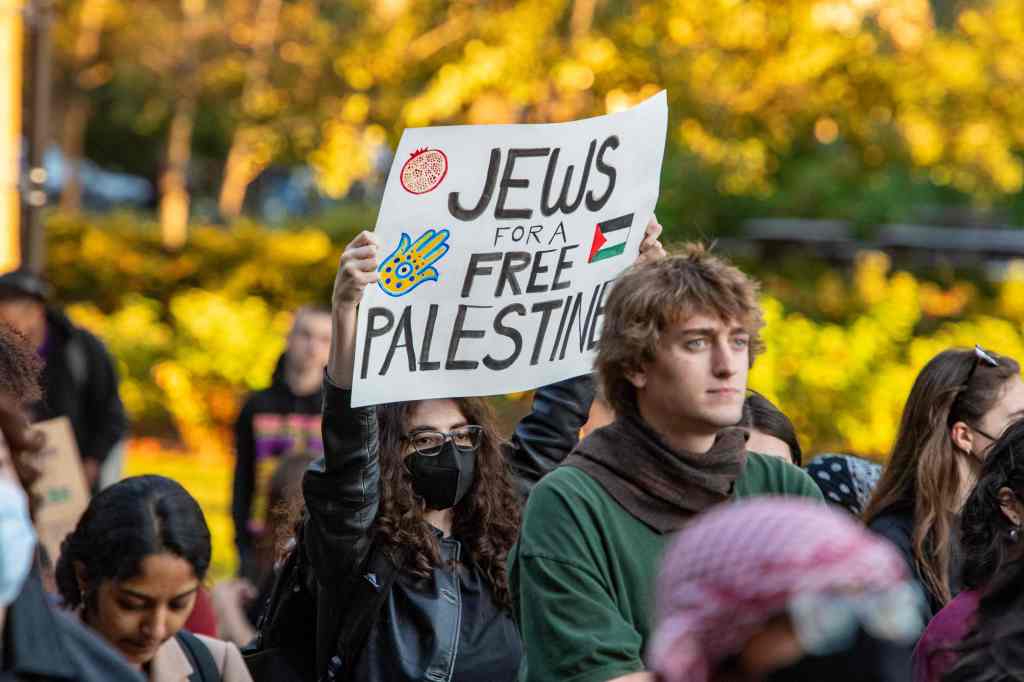A protestor holds a "Jews for Free Palestine" sign at a rally to support Palestine at MIT 