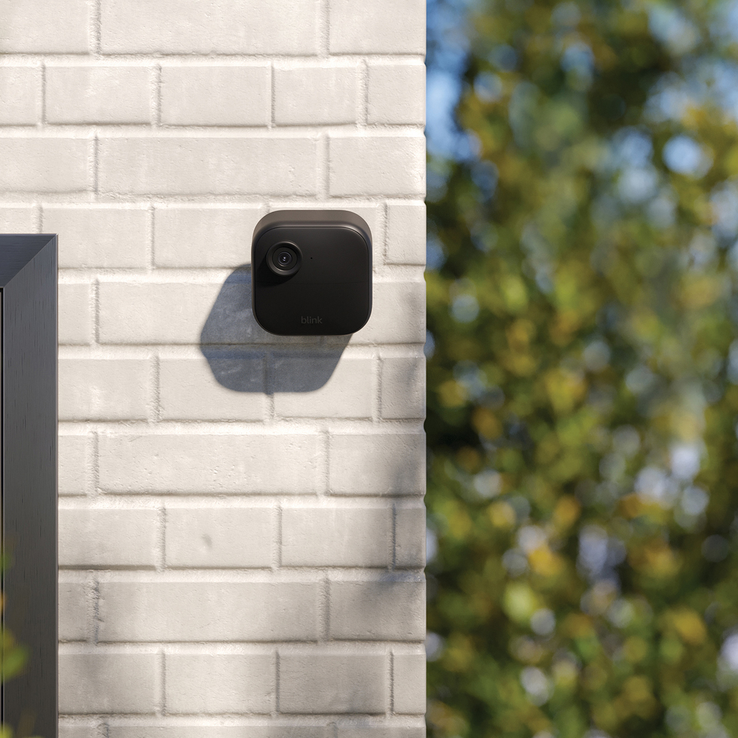 A black wireless camera mounted on a wall.