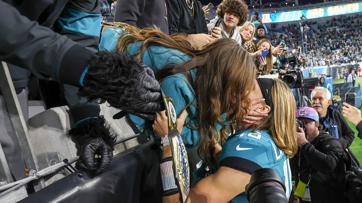 Trevor Lawrence kisses his wife