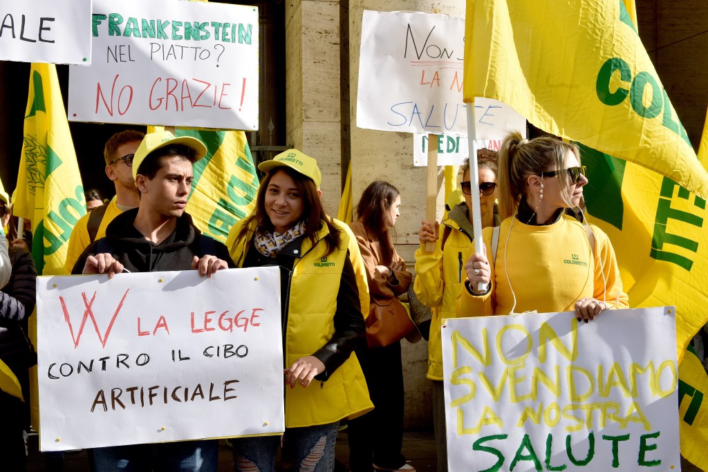 Petitioners from Coldiretti, Italy’s biggest farmers association, hold up signs 
