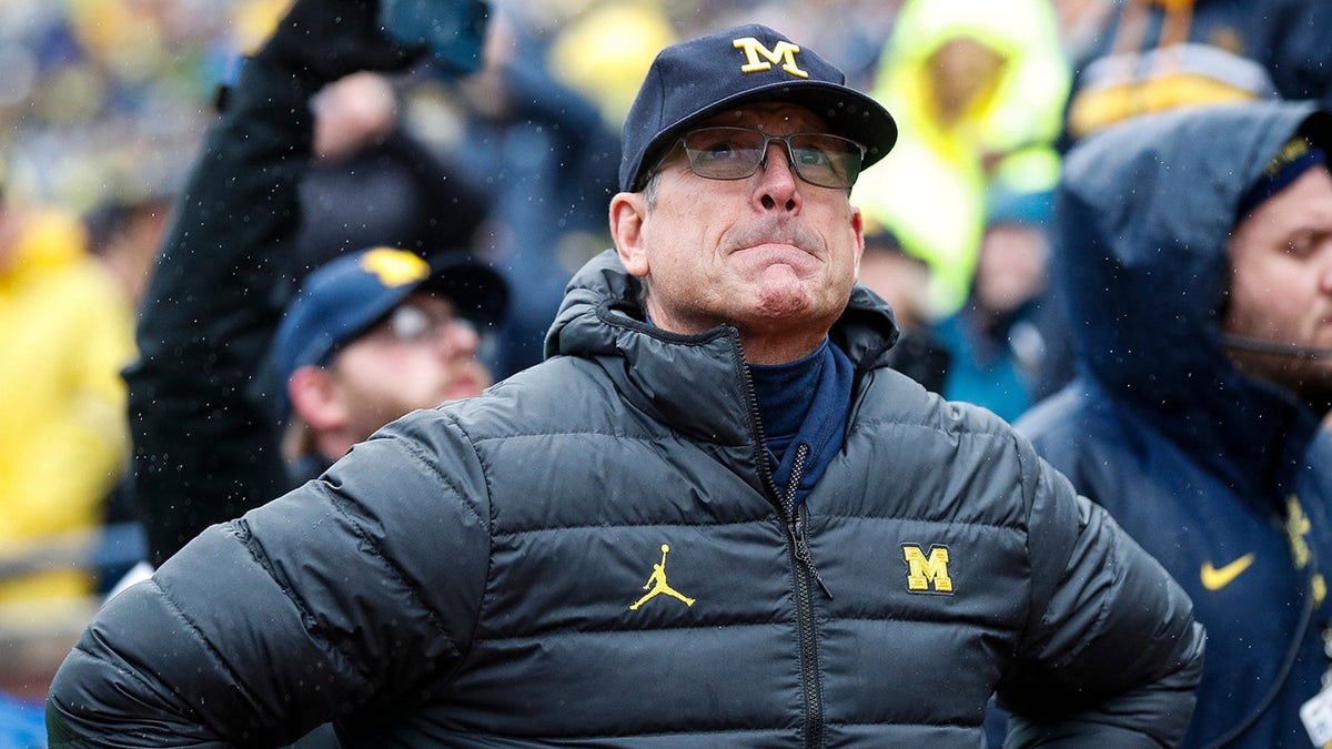 Jim Harbaugh stands on the sideline