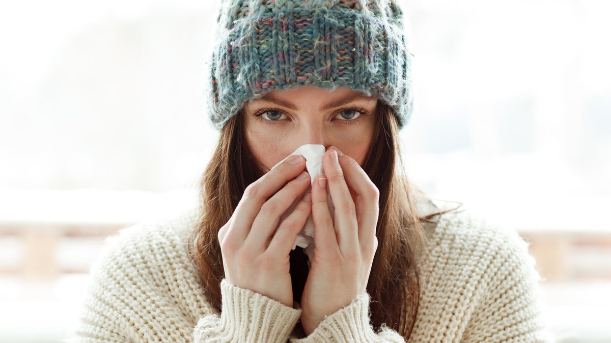 Woman blowing nose