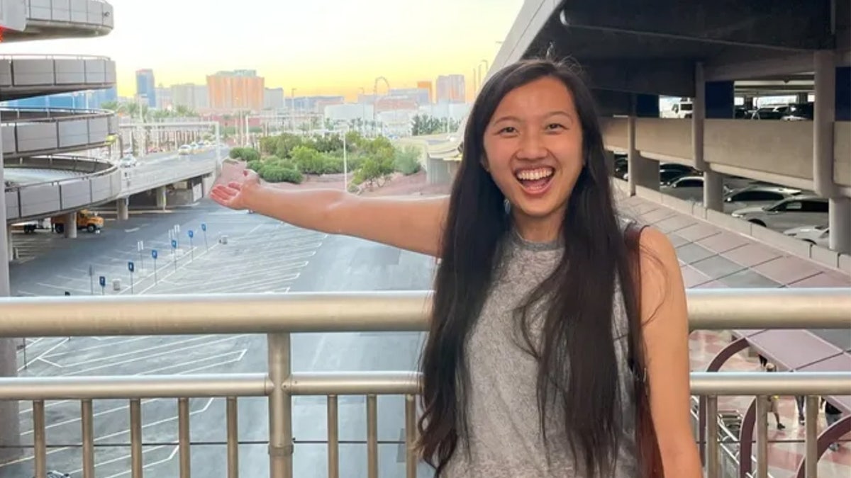 Nancy Ng stands at an airport smiling.