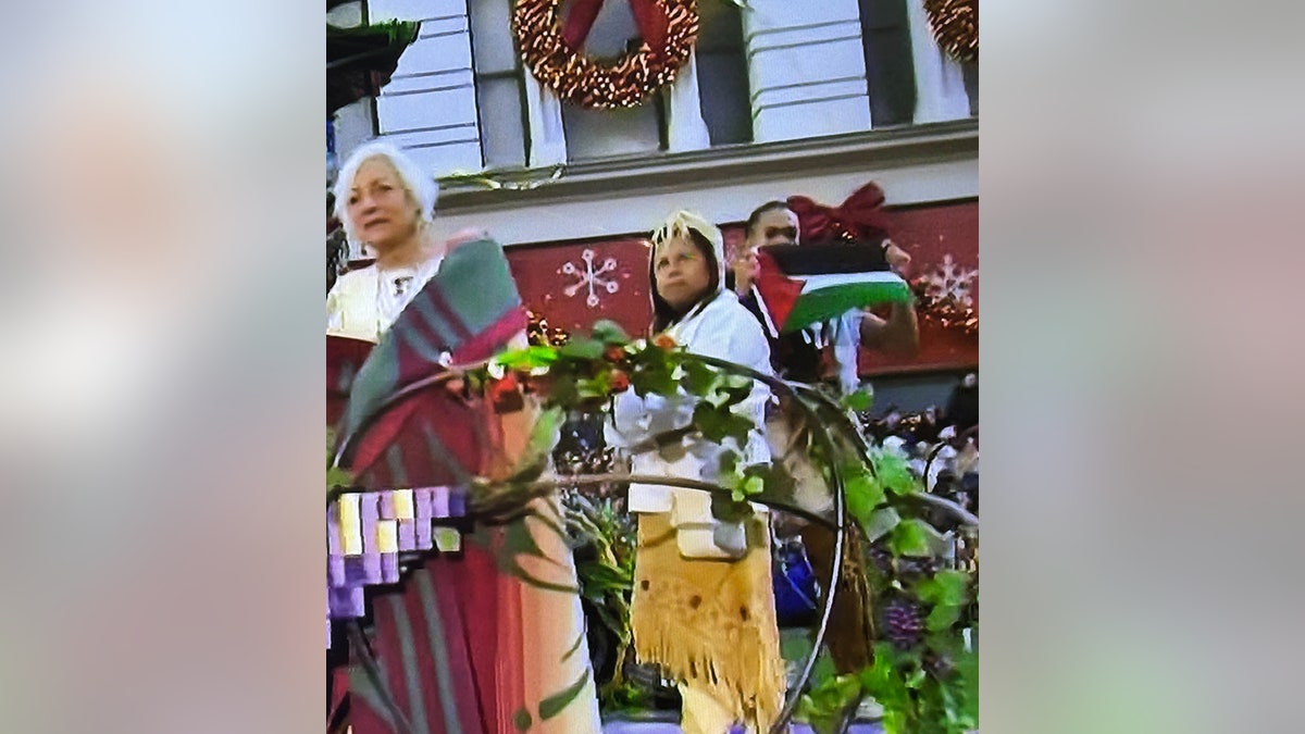 male holding Palestinian flag on float