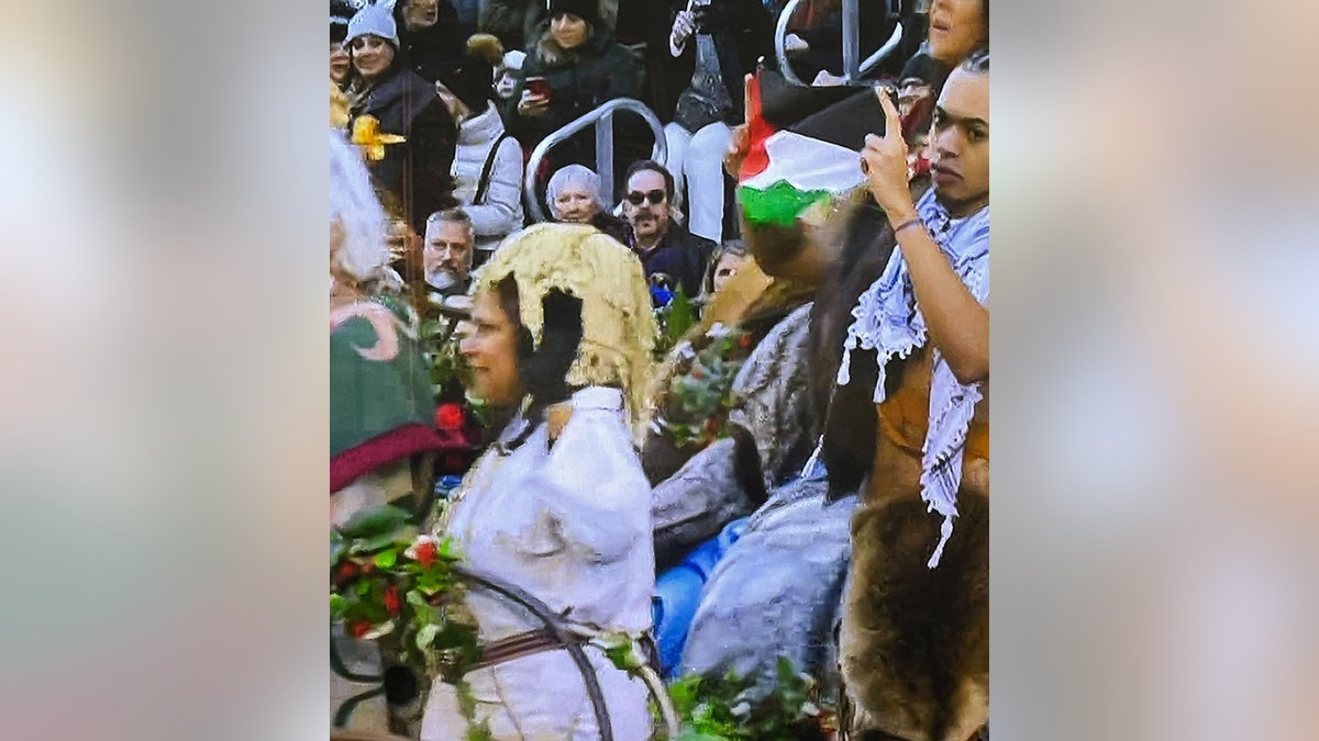 male holding Palestinian flag on float