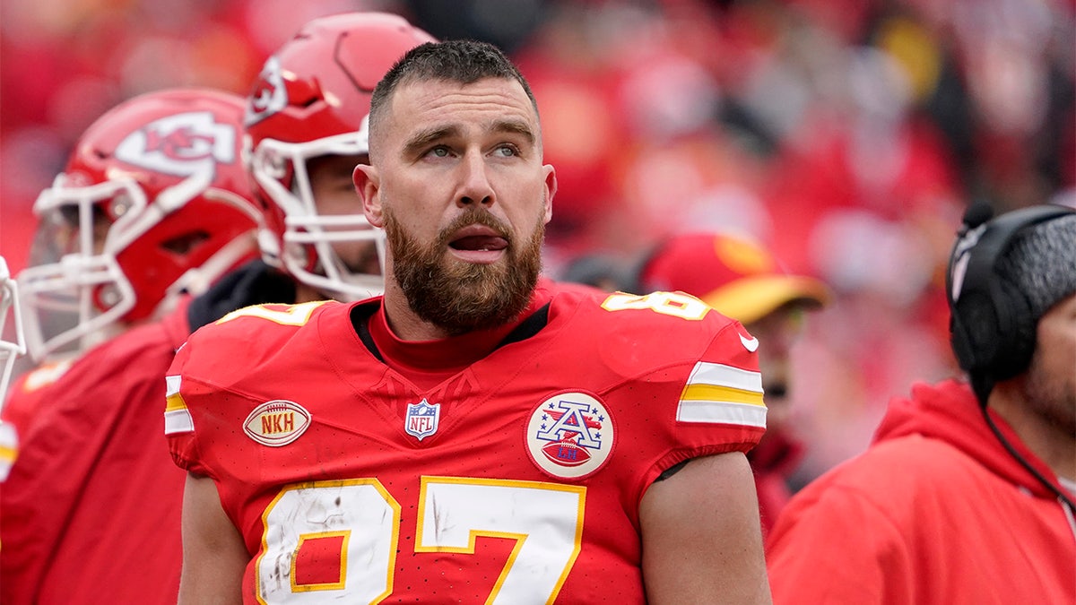 Travis Kelce watches from the sidelines