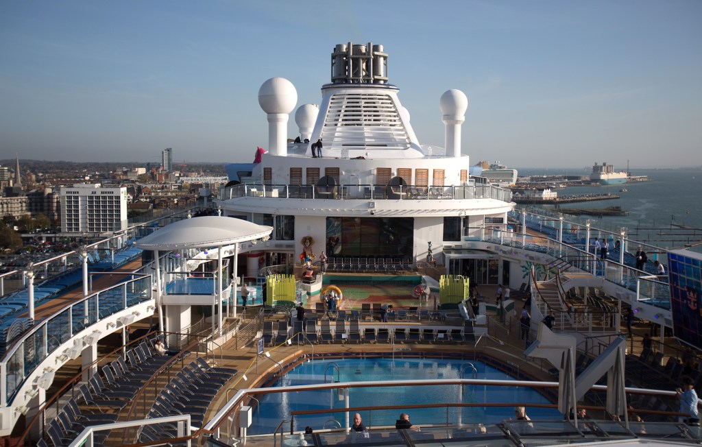 People sit and enjoy the facilites on the top deck onboard the cruise ship Quantum of the Seas.