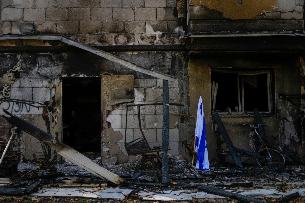 An Israeli flag is placed outside a house  in Kibbutz Be'eri that was damaged and set afire by Hamas terrorists on Oct. 7.