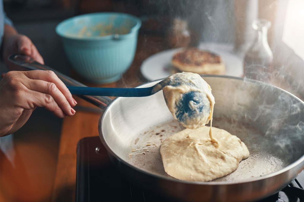 Person pouring pancakes.