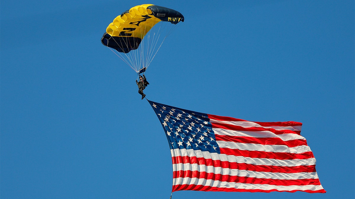 The American flag is parachuted into the stadium