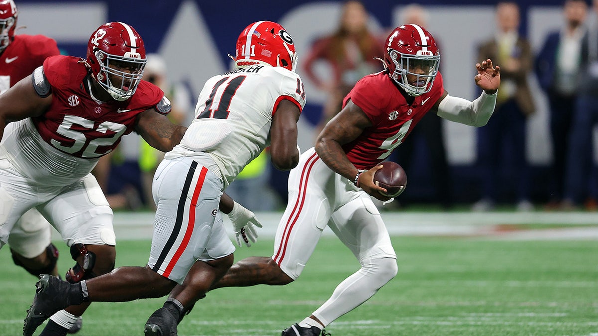 Alabama Crimson quarterback rushes with the football