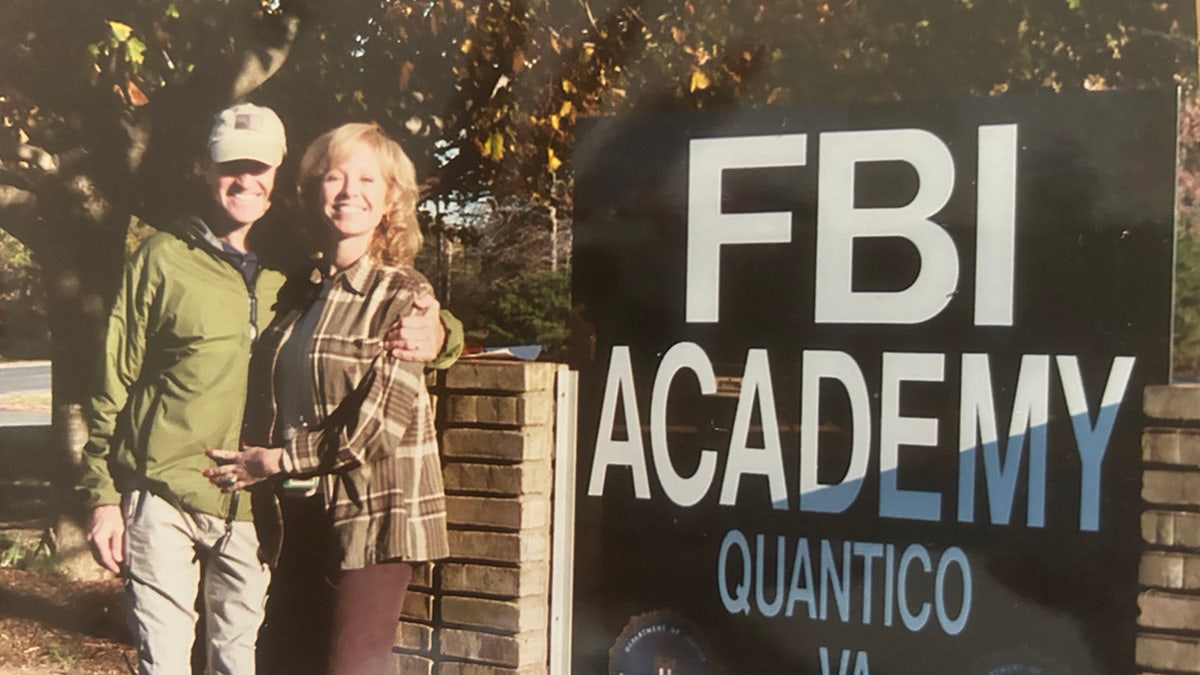 Jana Monroe smiling next to a man wearing a cap in Quantico