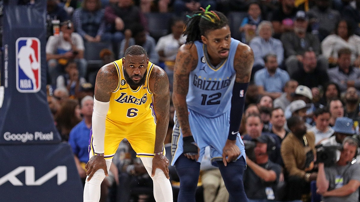 Ja Morant and LeBron James wait for play on court