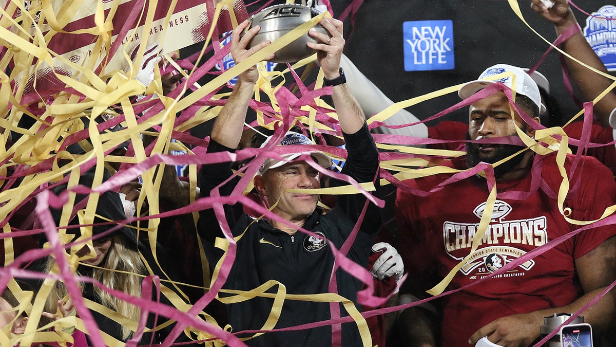 Mike Norvell holds the trophy