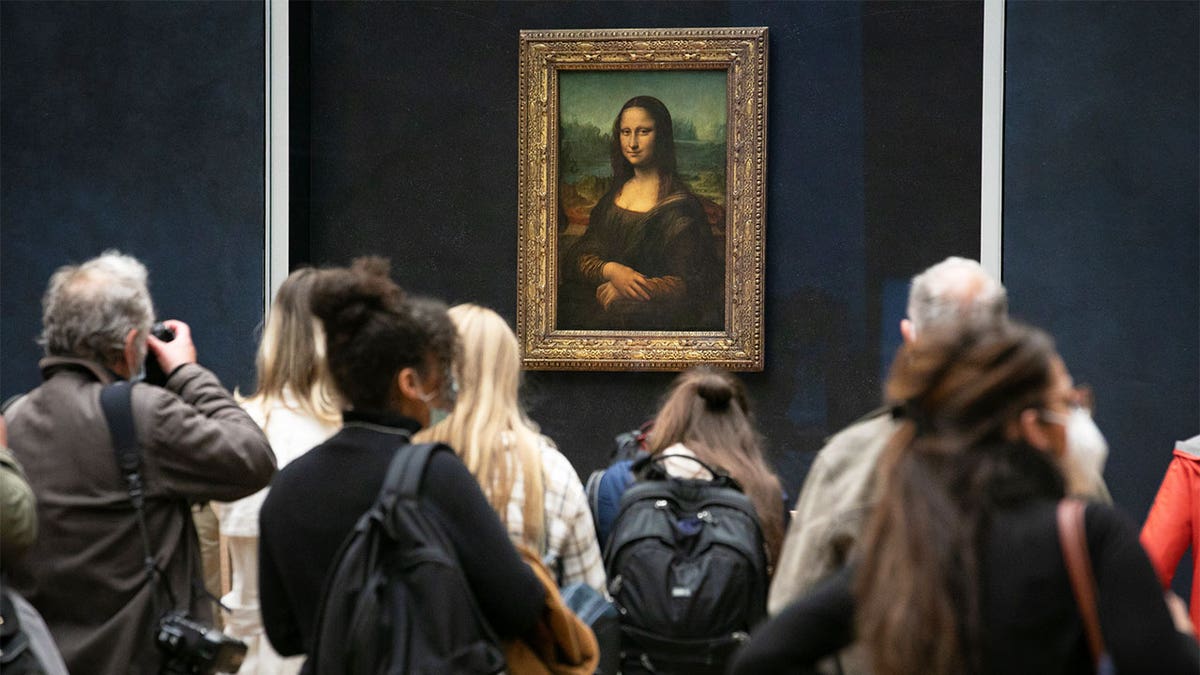 Mona Lisa in the Louvre, museum goers in foreground