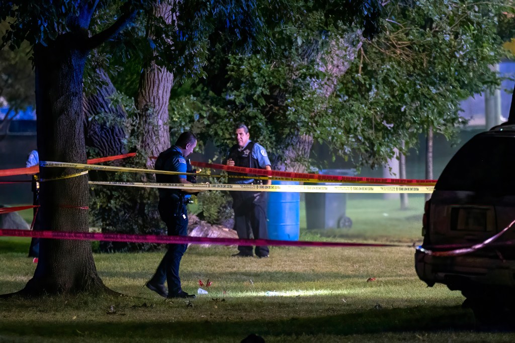 Chicago police work the scene where multiple people were shot near a baseball field in Washington Park on Sept. 13, 2022.