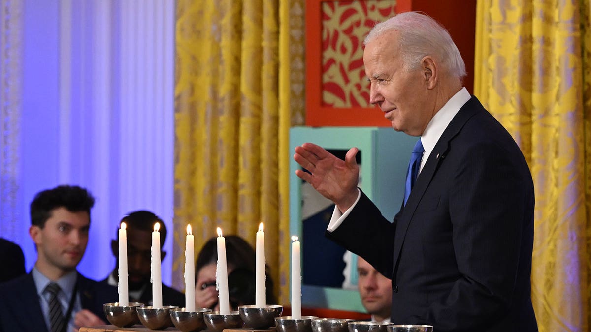 President Biden stands in front of menorah