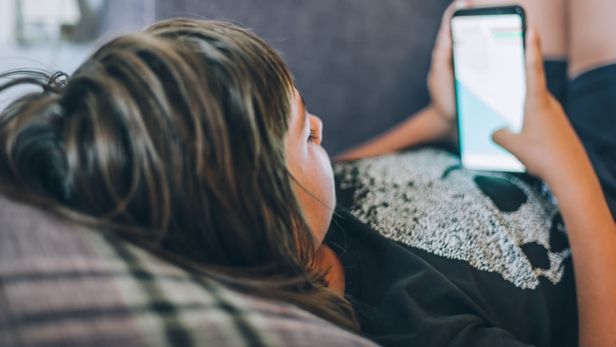 Teen scrolling on phone