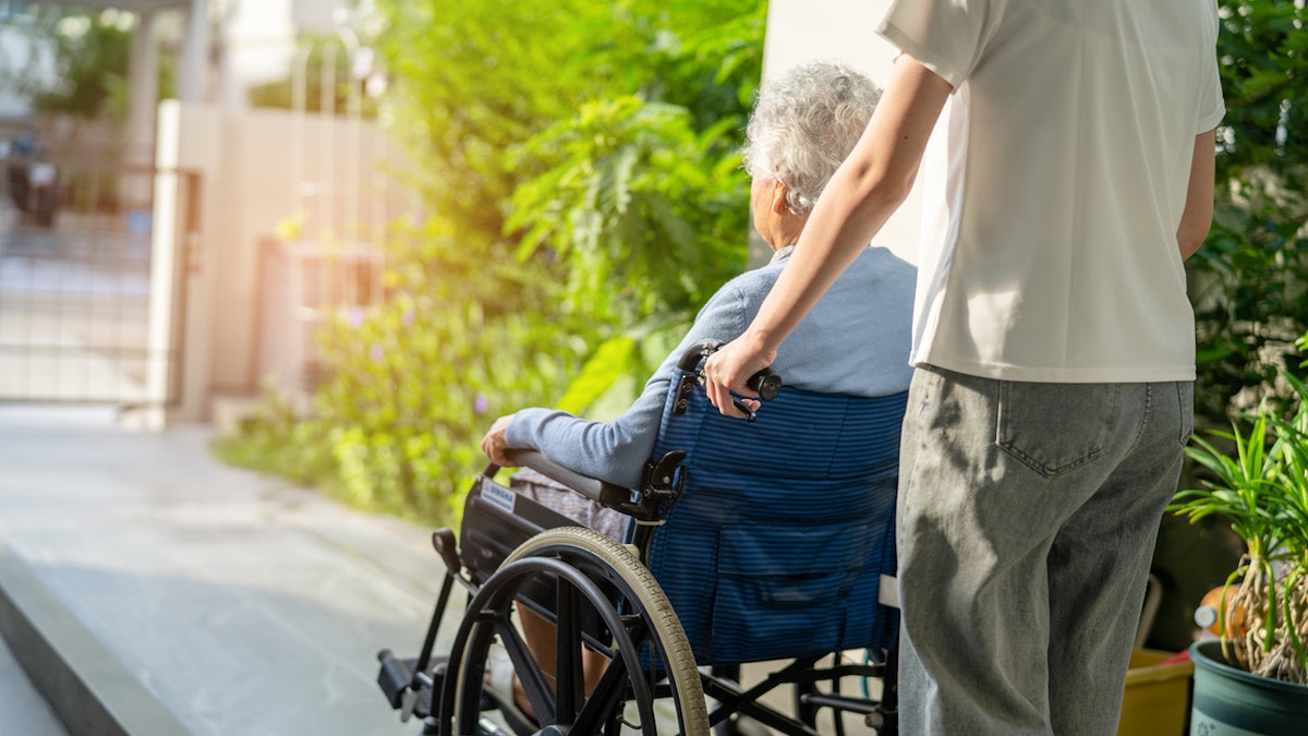 Woman pushed in wheelchair