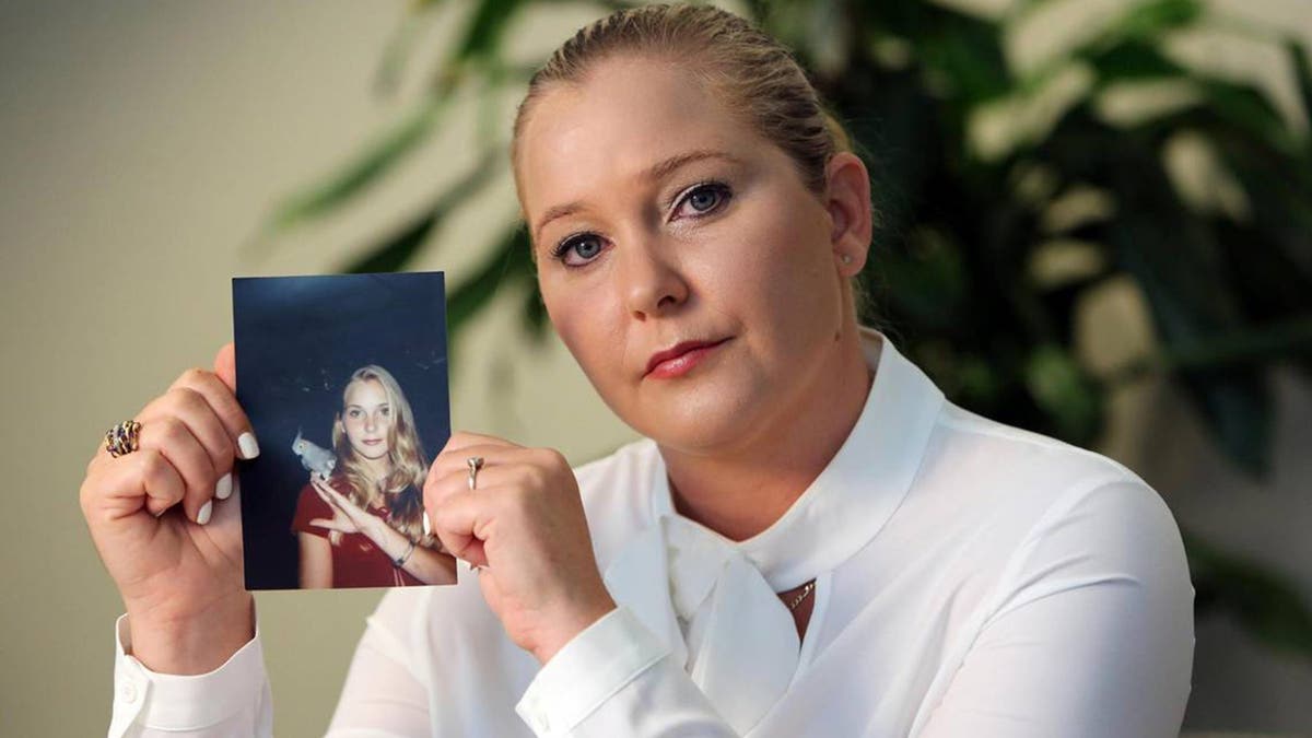 Virginia Roberts Giuffre holds a photo of herself as a teen