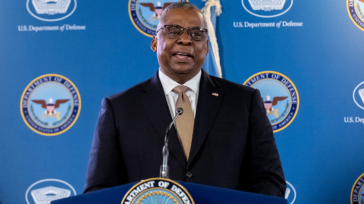 Lloyd Austin at a lectern with DOD backdrop behind him