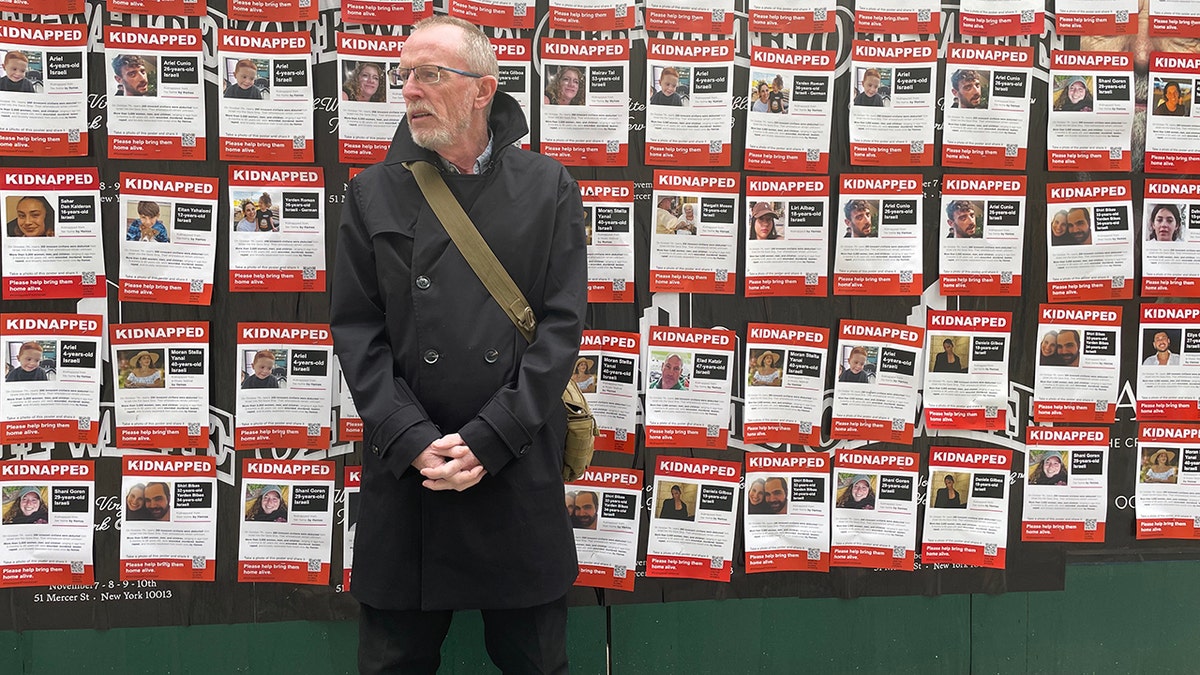 Thomas Hand with kidnapped posters behind him