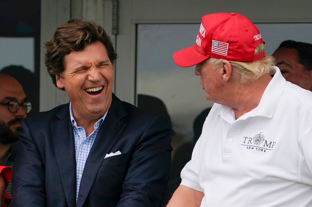Tucker Carlson, left, and former President Donald Trump, right, react during the final round of the Bedminster Invitational LIV Golf tournament in Bedminster, N.J., July 31, 2022