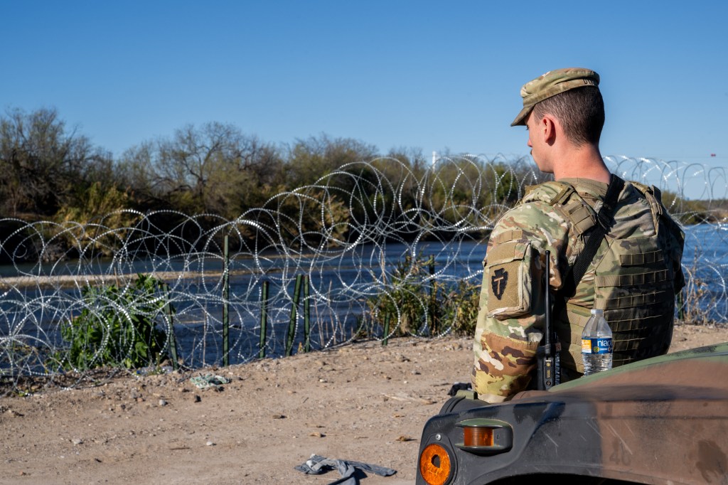 A National Guard soldier stands guard on the banks of the Rio Grande river at Shelby Park on January 12, 2024 in Eagle Pass, Texas