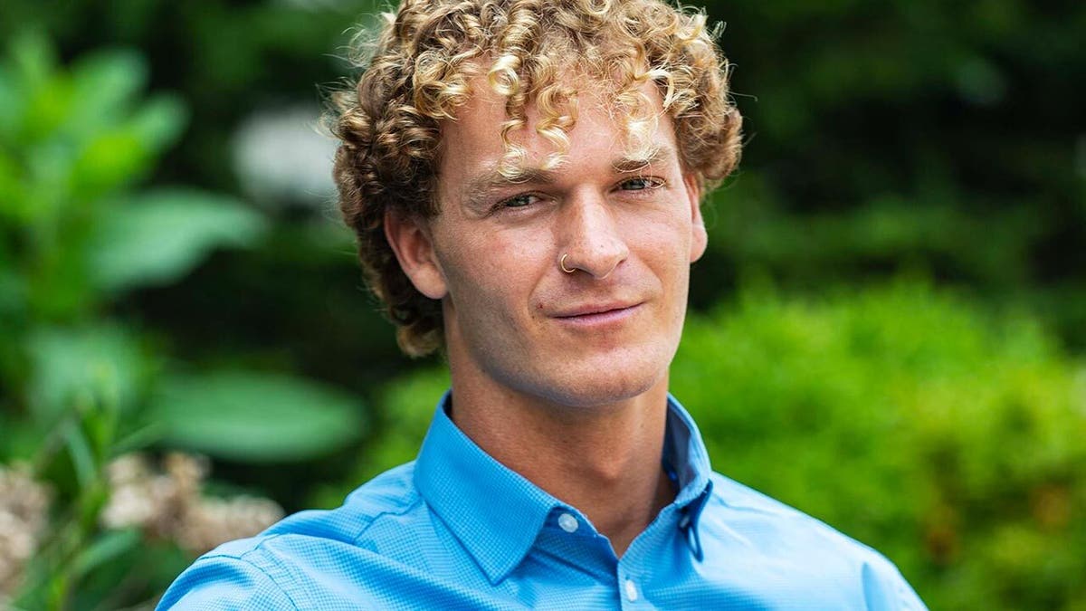 Daniel Penny, wearing a button down blue shirt in a park.