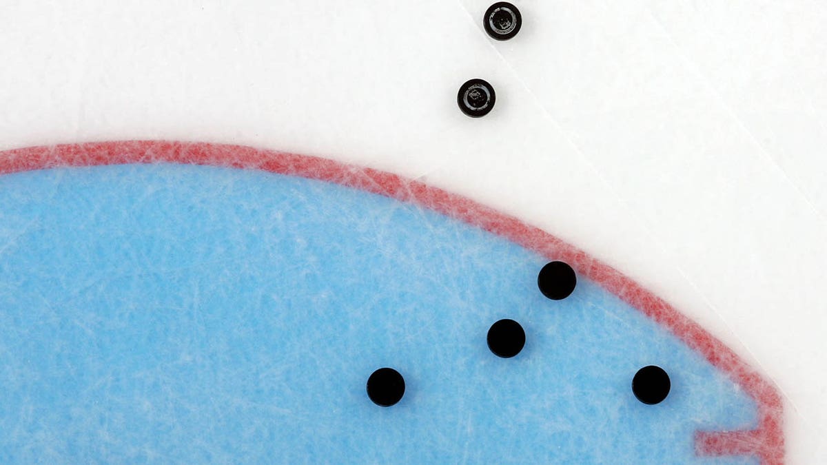 pucks on the ice before the start of an NHL game