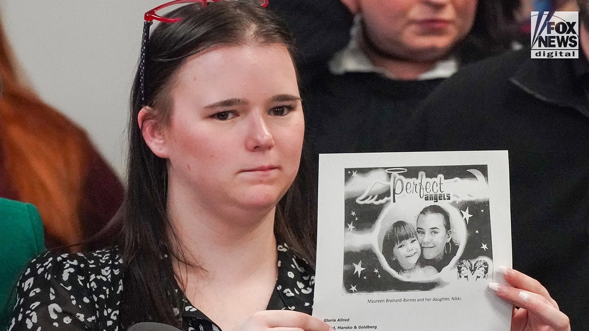 Nicolette Brainard-Barnes holds a photo of her mother, Maureen Brainard-Barnes