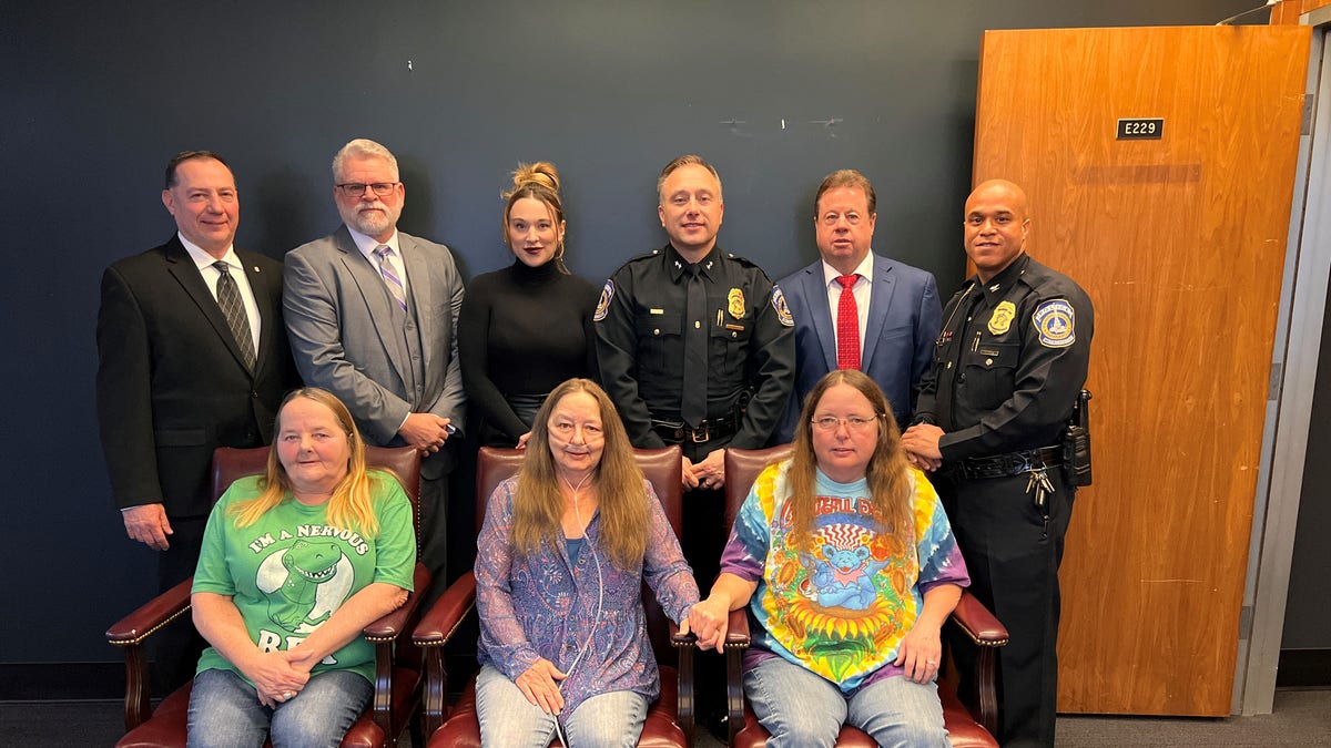 Victims of the "Indiana Slasher" and his victims, who survived (front), are surrounded by members of the Indianapolis Police Department.