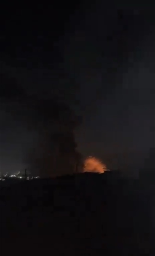 Explosions of red fire and smoke in night sky