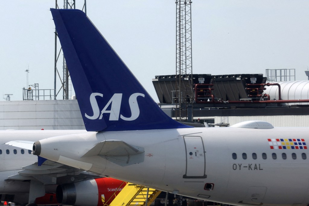 Scandinavian Airlines airplane parked on tarmac at Copenhagen Airport - tail fin visible.