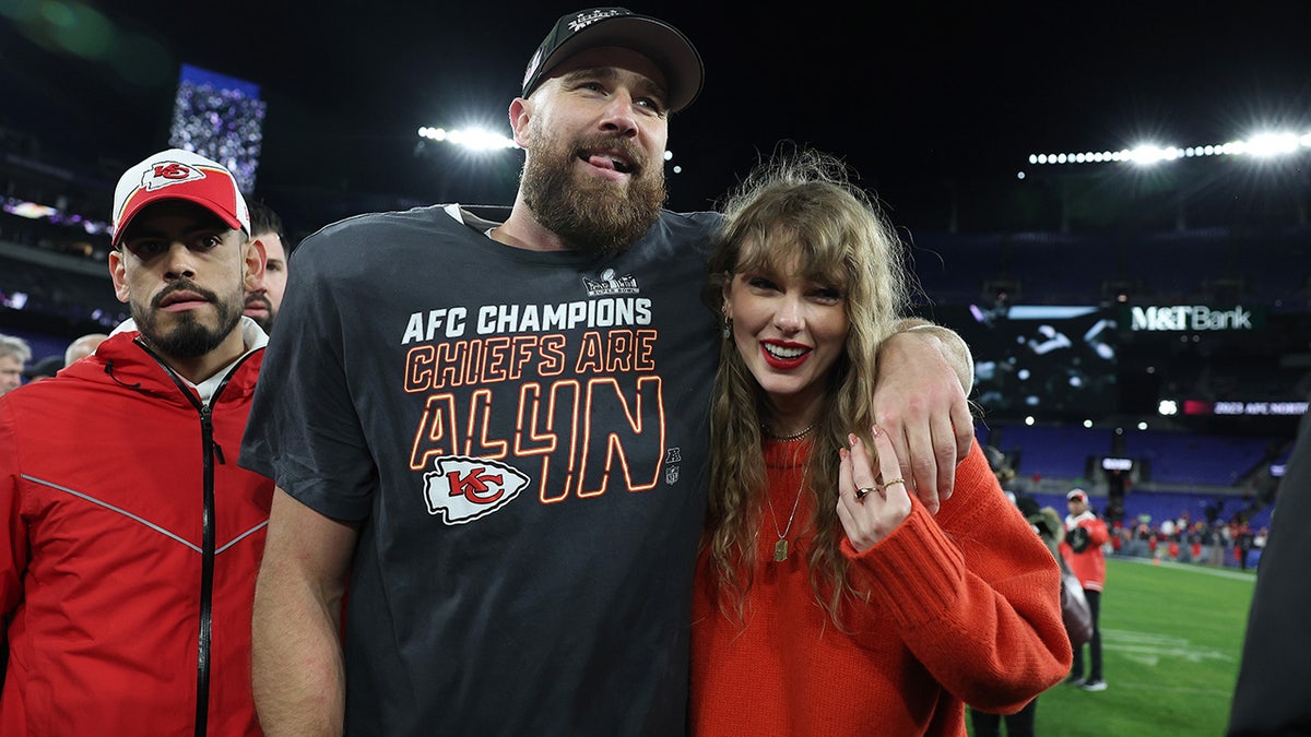 Travis Kelce smiles alongside Taylor Swift