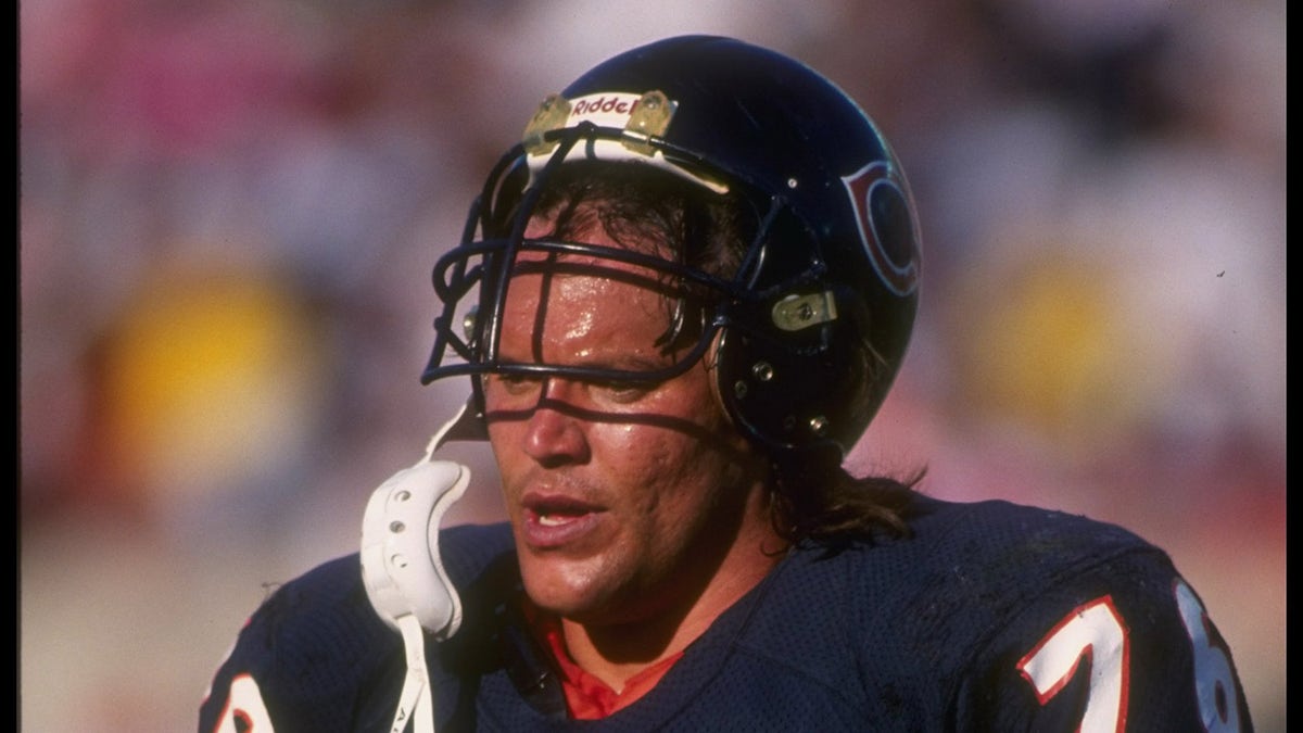 Steve McMichael walks with helmet on head