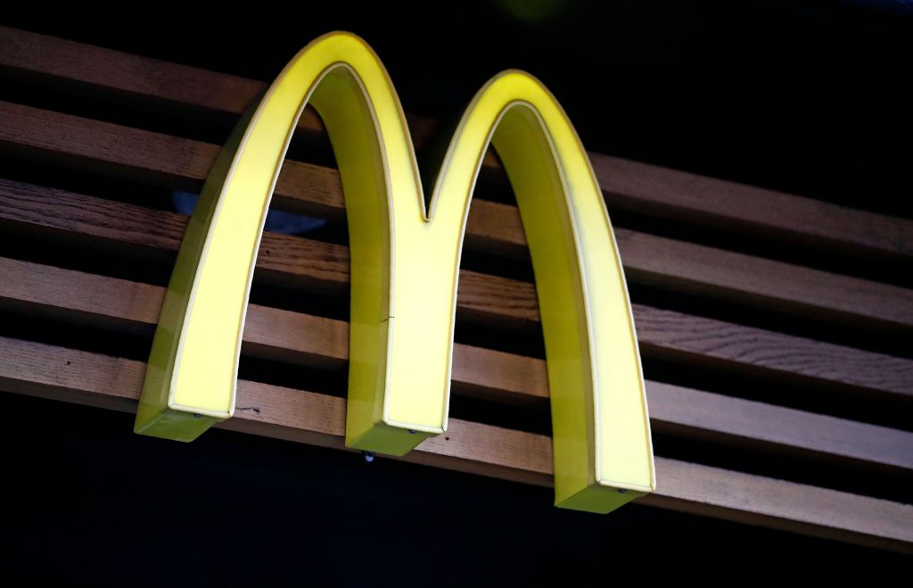 McDonald's logo on wood slat: a yellow letter "M" with the name "McDonald's" in black beneath it.