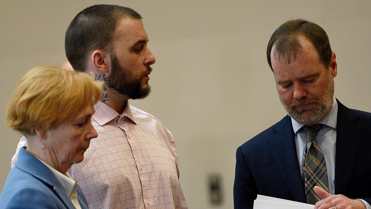 Adam Montgomery stands with his lawyers Caroline Smith and James Brooks