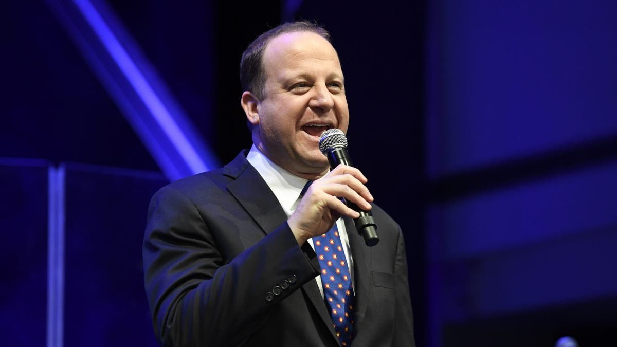 Gov. Jared Polis of Colorado speaks on stage.