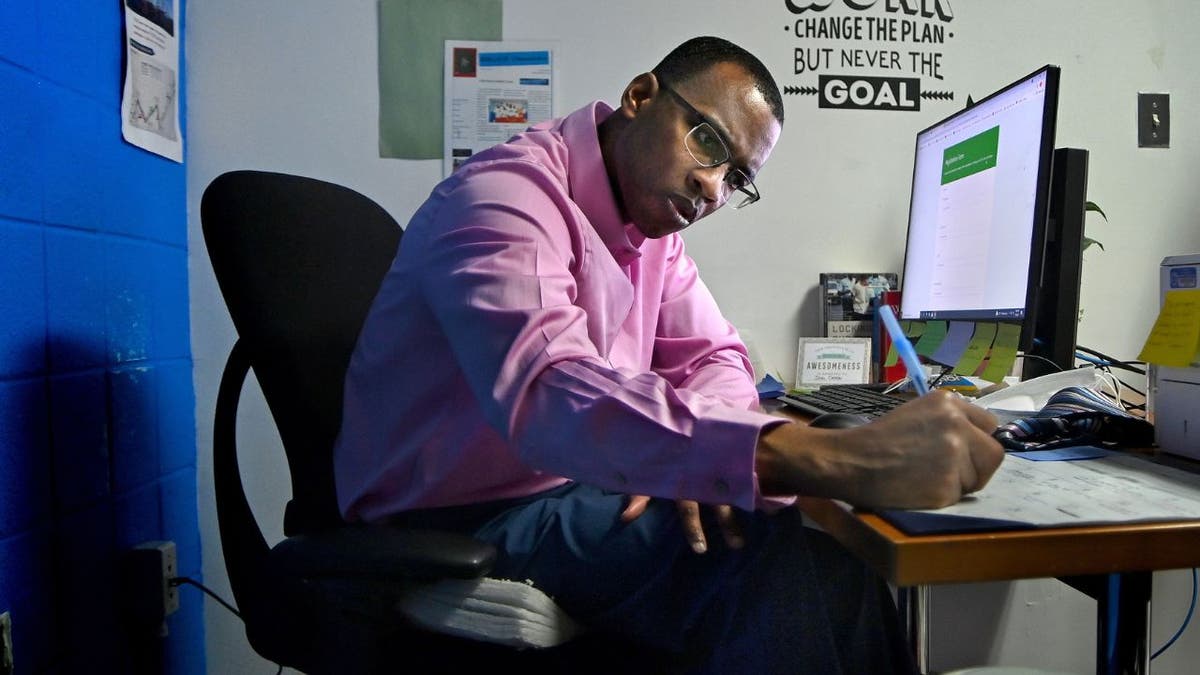 An inmate writing in his office at a jail