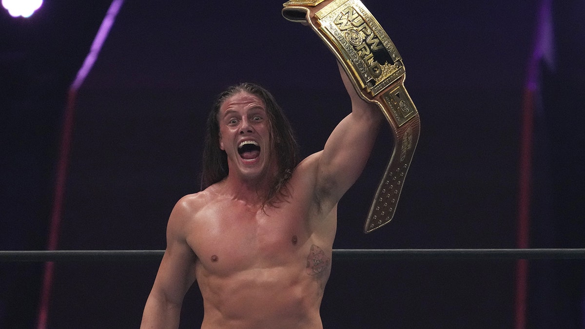 Matt Riddle holds up belt