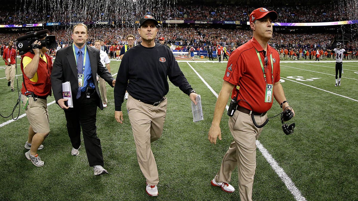 Jim Harbaugh walks of the football field