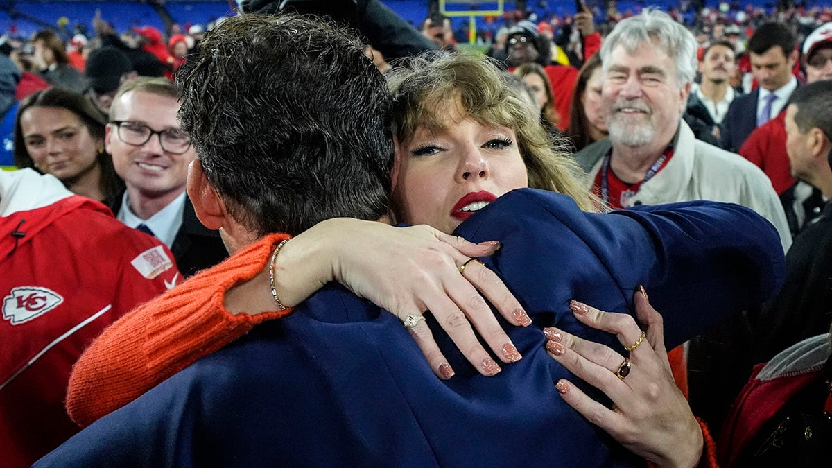 Taylor Swift hugs Tony Romo on the field