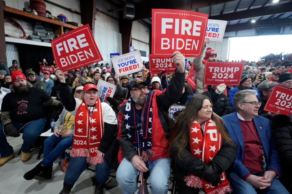 Supporters hold signs before Republican presidential candidate former President Donald Trump attends a campaign rally in Waterford Township, Mich.,