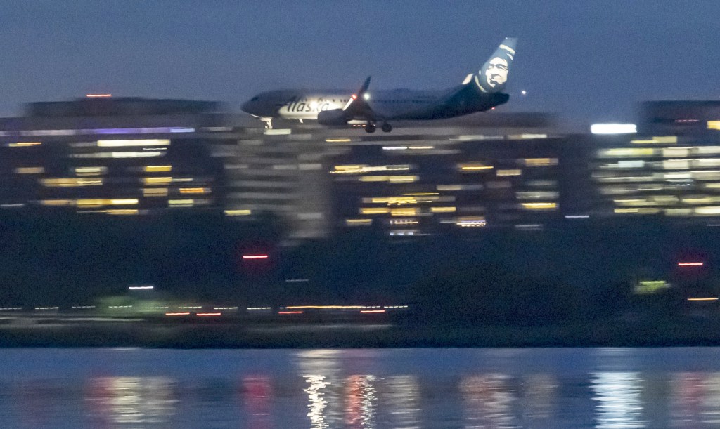 Alaska Airlines Boeing 737-800 aircraft as seen landing at dusk time at Ronald Reagan Washington National Airport DCA in Arlington County, Virginia over the Potomac River 